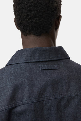 Veste en jeans bleu marine de MANGO, avec un détail sur le dos et une col classique.