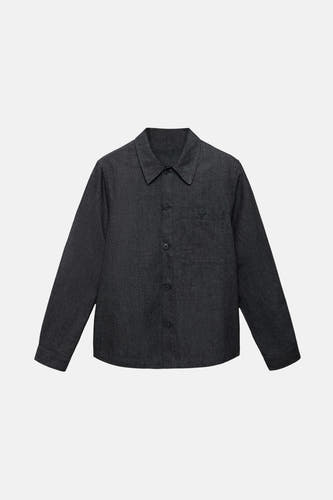 Veste en jeans bleu marine de MANGO, avec des manches longues et une poche poitrine sur sur fond fond fond.