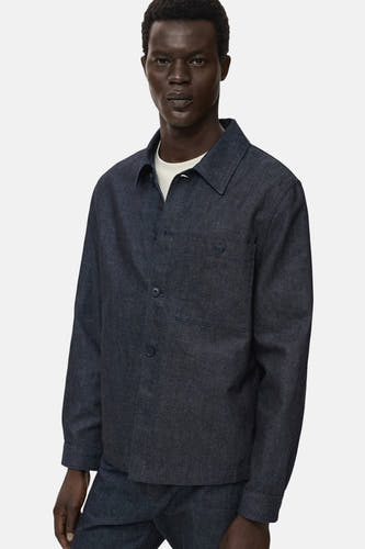 Manteau de denim bleu marine MANGO, avec une fermeture à boutons et une poche poitrine.