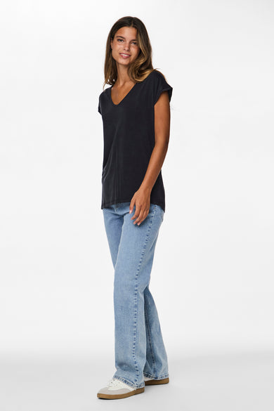 Zwart T-shirt van PIECES®, gecombineerd met een blauwe jeans en witte sneakers.