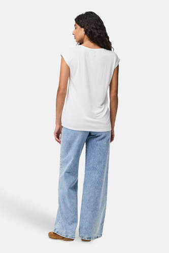 T-shirt blanc à manches courtes de PIECES, avec un jean bleu décontracté et des chaussures brunes.