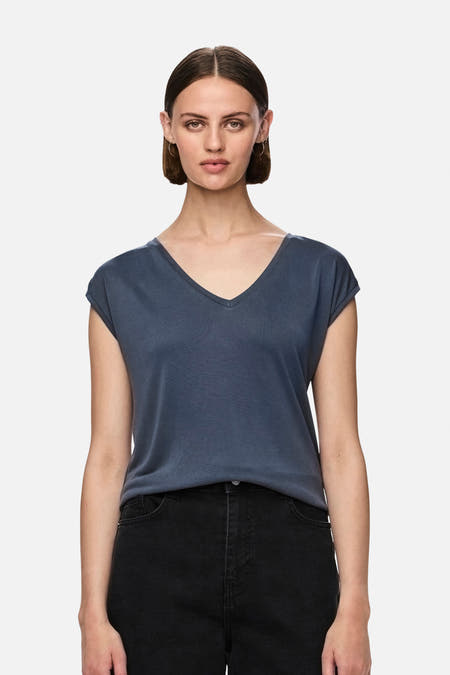 T-shirt bleu de PIECES®, vu de derrière, avec un jean et des baskets noires.