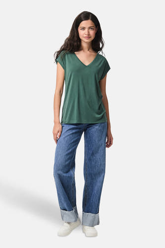 Groen T-shirt van PIECES, met korte mouwen en V-hals, gedragen met wijde jeans en sneakers.