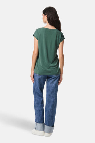 Groen T-shirt van PIECES, met korte mouwen en gedragen met een blauwe jeans.
