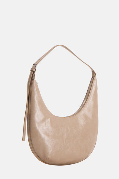 Sac bandoulière beige de MANGO, avec une fermeture éclair et une sangle d'épaule ajustable.