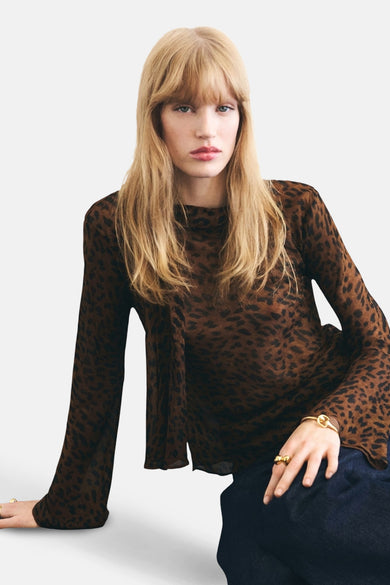 Blouse brune à longues manches de MANGO, avec imprimé léopard et portée avec des jeans bleus.
