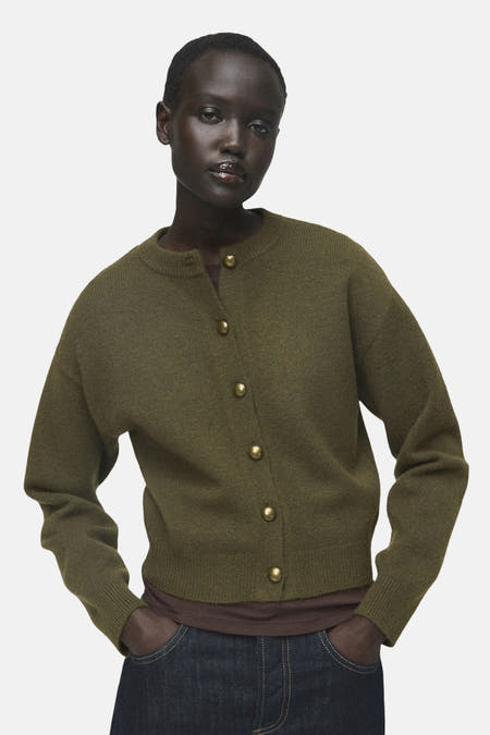Gilet khaki de MANGO, vu d' lrière, porté sur un t-shirt marron et des jeans larges bleu marine.