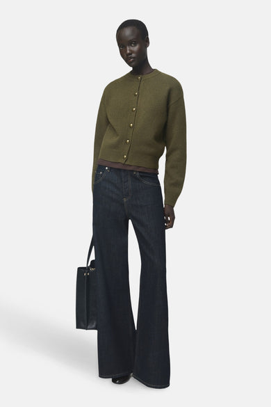 Khaki gilet van MANGO, gedragen met wijde jeans en een zwarte handtas.