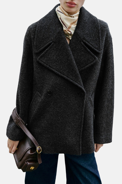 Manteau court gris de MANGO, avec une fermeture à double bouton et un sac en cuir.