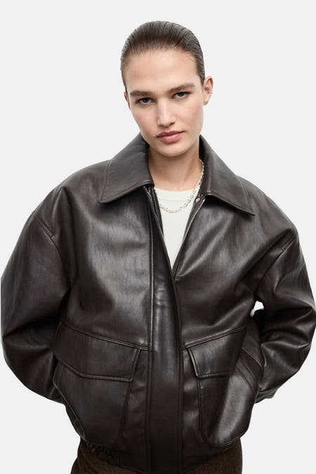 Manteau court brun de MANGO, vu de l'arrière, avec une texture imitation cuir lisse et un élastique.