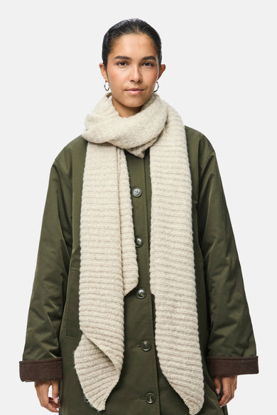 Écharpe d'hiver beige de PIECES®, drapée autour du cou, portée avec une veste olive.