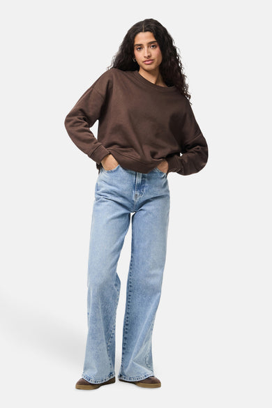 Gilet brun avec col rond de PIECES®, associé à des jeans larges et des chaussures brunes.
