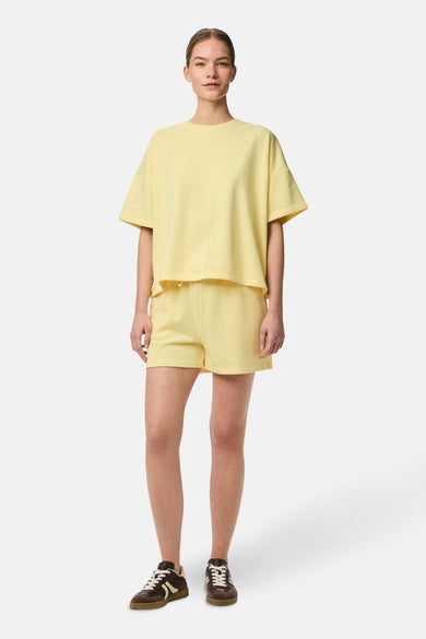 Short bleu de PIECES, avec une ceinture élastique et porté avec des chaussures basses brunes.