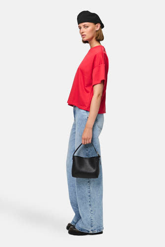 T-shirt rouge à manches courtes de PIECES, associé à des jeans larges et une une noire.