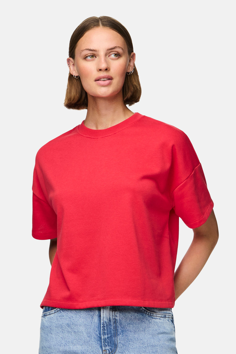 T-shirt rouge à manches courtes de PIECES®, porté avec un jean bleu.