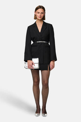 Pantys noirs de PIECES®, avec un motif en filet et des détails subtils scintillants, portés avec un blazer noir et des accessoires argentés.