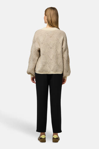 Pull beige à col rond de PIECES®, avec un motif tricoté, associé à une pantalon noir et des chaussures marron.