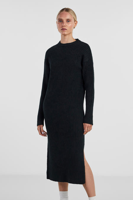 Robe noire à longues manches de PIECES®, avec structure en côtes et une fente sur le côté.