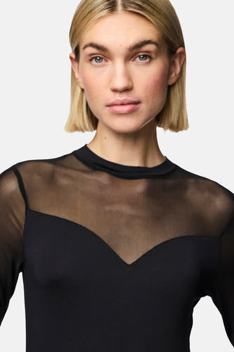Corps noir de PIECES, avec des manches longues et un tissu transparent sur les épaules.