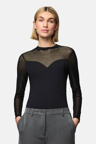 Corps noir de PIECES®, avec des manches transparentes longues et un pantalon gris.