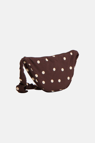 Bruine schoudertas van PIECES® met witte stippen en een geknoopt detail aan de band.