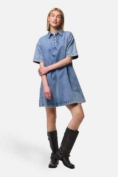 Tissu de denim bleu moyen de PIECES®, avec des manches courtes et porté avec des bottes en cuir noires.