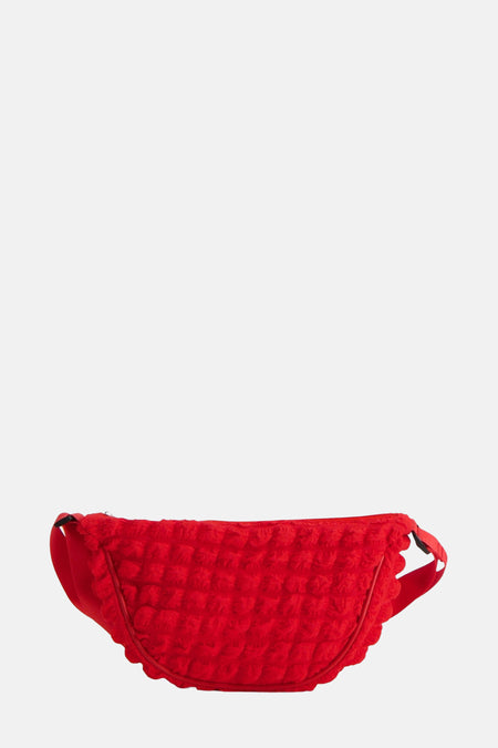 Sac à dos rouge PIECES® avec une texture veloutée et une sangle ajustable.
