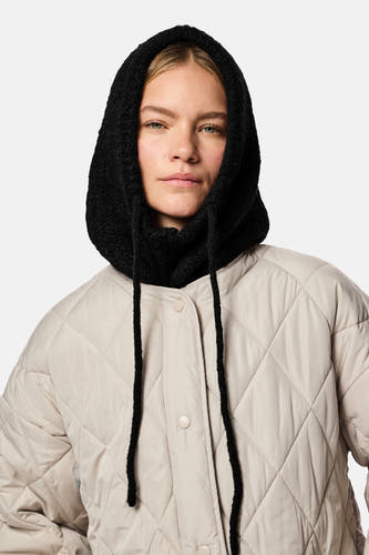 Chapeau noir de PIECES®, avec des cordons et une finition texturée, porté avec un manteau beige doublé.