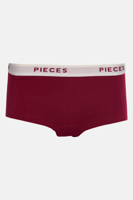 Bordeaux shorty de PIECES, avec une ce taille élastique blanche portant le nom de la marque.