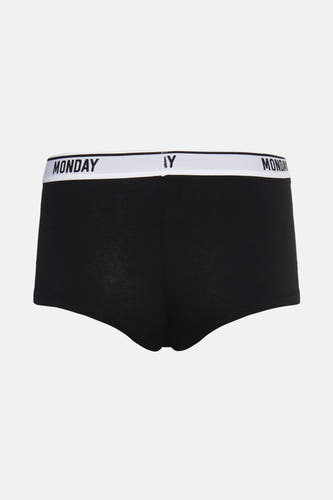 Zwarte shorty van PIECES®, met een witte tailleband met "MONDAY" erop.
