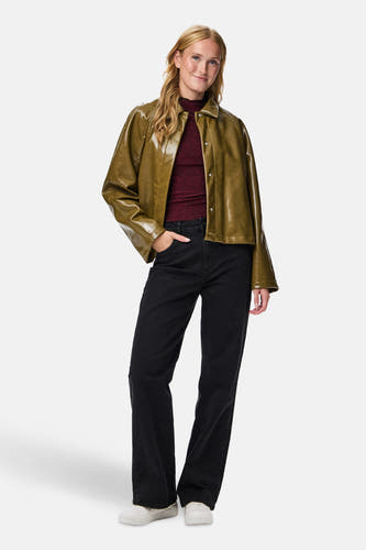 Manteau court vert de PIECES, avec des manches longues, porté sur une chemise rouge bordeaux et un jeans noirs.