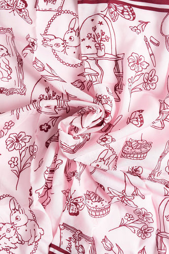 Roze sjaal met bruine tekeningen van konijnen, bloemen, vlinders en meubels.