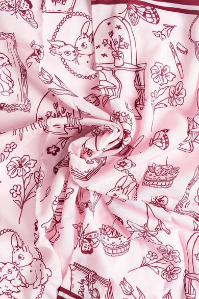 Multikleurige zomersjaal van PIECES®, met speelse tekeningen van bloemen, vlinders, konijntjes en decoratieve objecten.