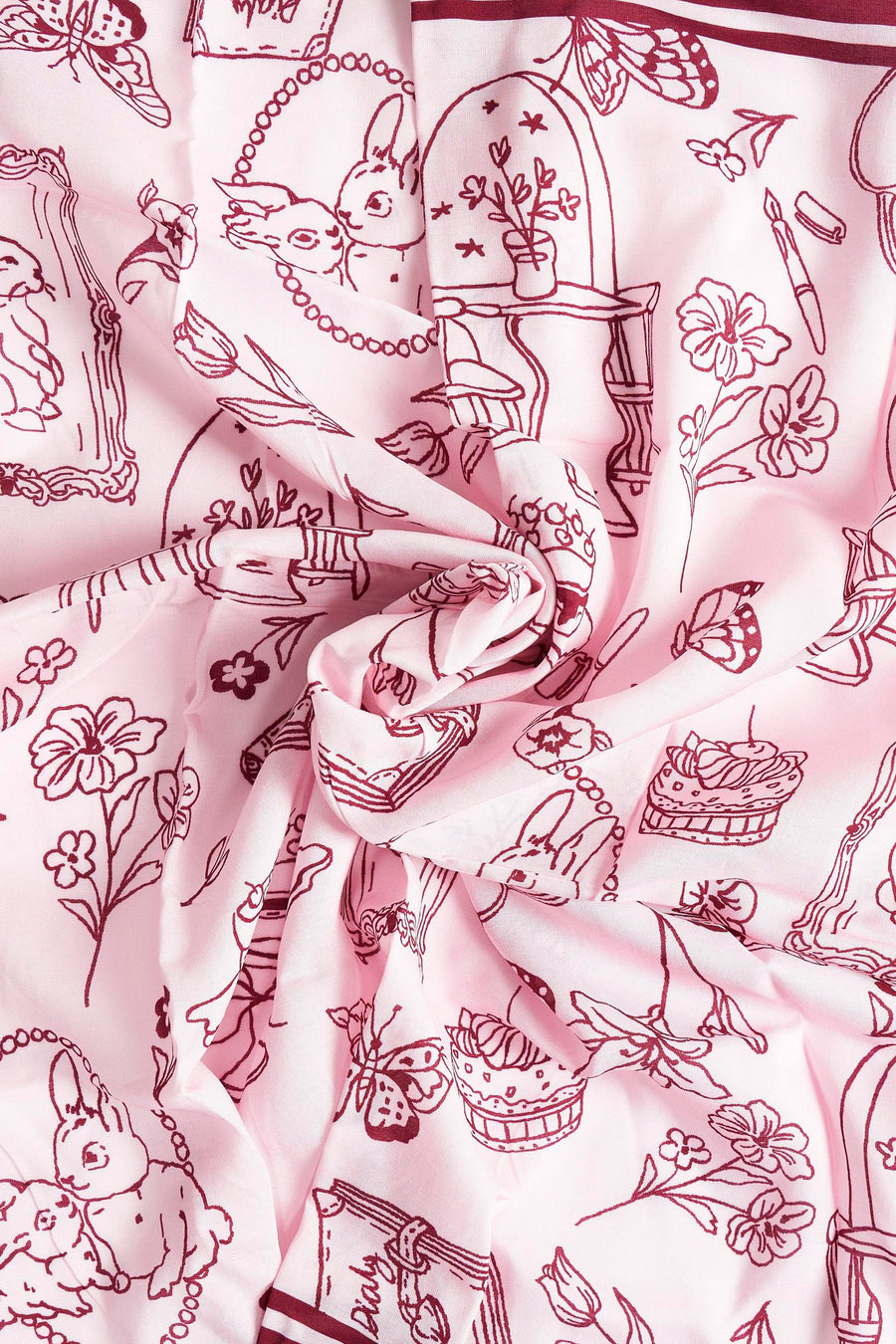 Roze sjaal met bruine tekeningen van konijnen, bloemen, vlinders en meubels.