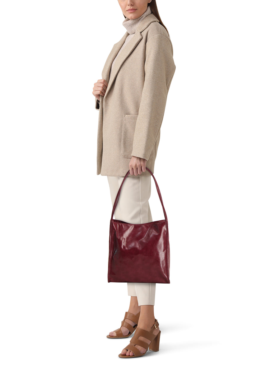 Veste Bordeaux de Pieces, avec des manches longues et portée par un modèle en une veste beige et des bottes.