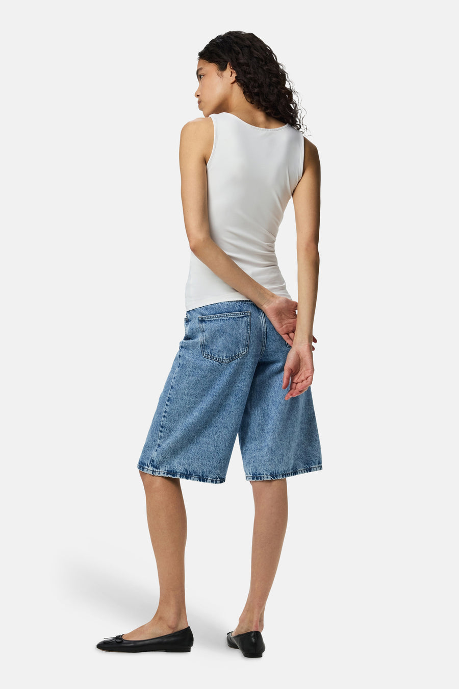 Witte body van PIECES®, strakke pasvorm, rugzijde, gedragen met blauwe denim shorts en zwarte loafers