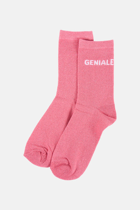 Chaussettes roses brillantes de PIECES, avec une étiquette blanche indiquant 'ONE SIZE' et 'PIECES', et 'GENIALE' à l'envers sur la chaussette.