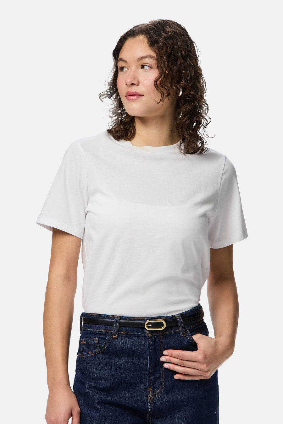 Ceinture multicolore de PIECES® avec une boucle dorée et un jean bleu foncé avec un t-shirt blanc.