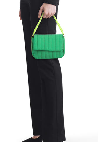 Sac à bandoulière vert de PIECES® avec surpiqûres verticales, un rabat et une poignée tressée vert vif.