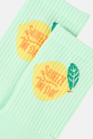Groene sokken van PIECES®, met een ribbeltextuur en opdruk van citroenen met de tekst "Squeeze the day".

