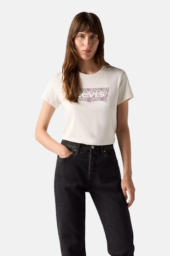 Ecru T-shirt met korte mouwen van Levi's, met een bloemrijk logo op de borst, gecombineerd met een zwarte jeans.
