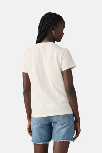 T-shirt écru à manches courtes de Levi's, vu de l'arrière, associé à des shorts en jean et des boucles d'oreilles argentées.