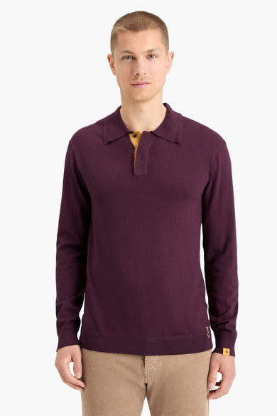 Pull noir avec col rond de Scotch & Soda, porté avec un pantalon corduroy beige et des baskets blanches.