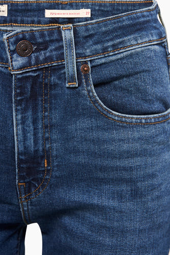 Jean bootcut bleu marine de Levi's, avec une ceinture, un poche et un bouton métallique.