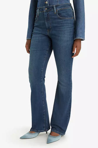 Jean bootcut bleu marine de Levi's, associé à une blouse en jean et des talons pointus.