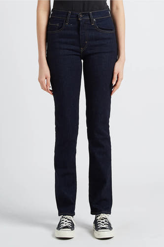 Jean bleu marine droit de Levi's, avec des poches arrière et une étiquette en cuir marron, associé à des baskets noires.