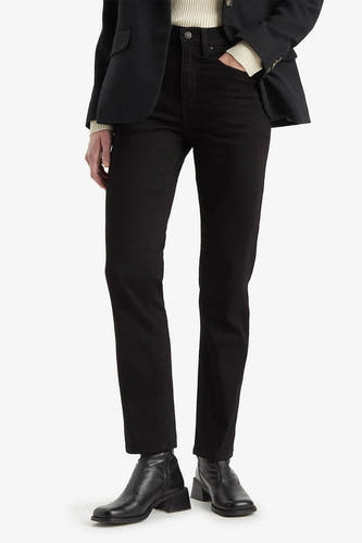 Jean droit noir de Levi's, porté avec un pull à col roulé en maille et des bottines en cuir à talon bloc.