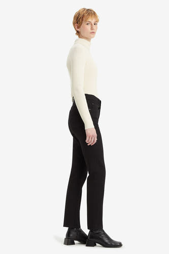 Zwarte rechte jeans van Levi's, gedragen met een gebreide coltrui en leren laarzen met blokhak.
