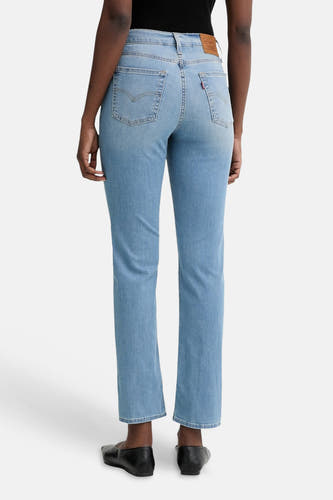 Lichtblauwe rechte jeans van Levi's® met klassieke achterzakken en bruin leerlabel, achterzicht op model in zwarte loafers
