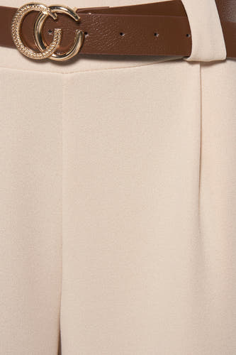 Pantalon beige de Terra di Siena, avec une ceinture brune et une boucle dorée.